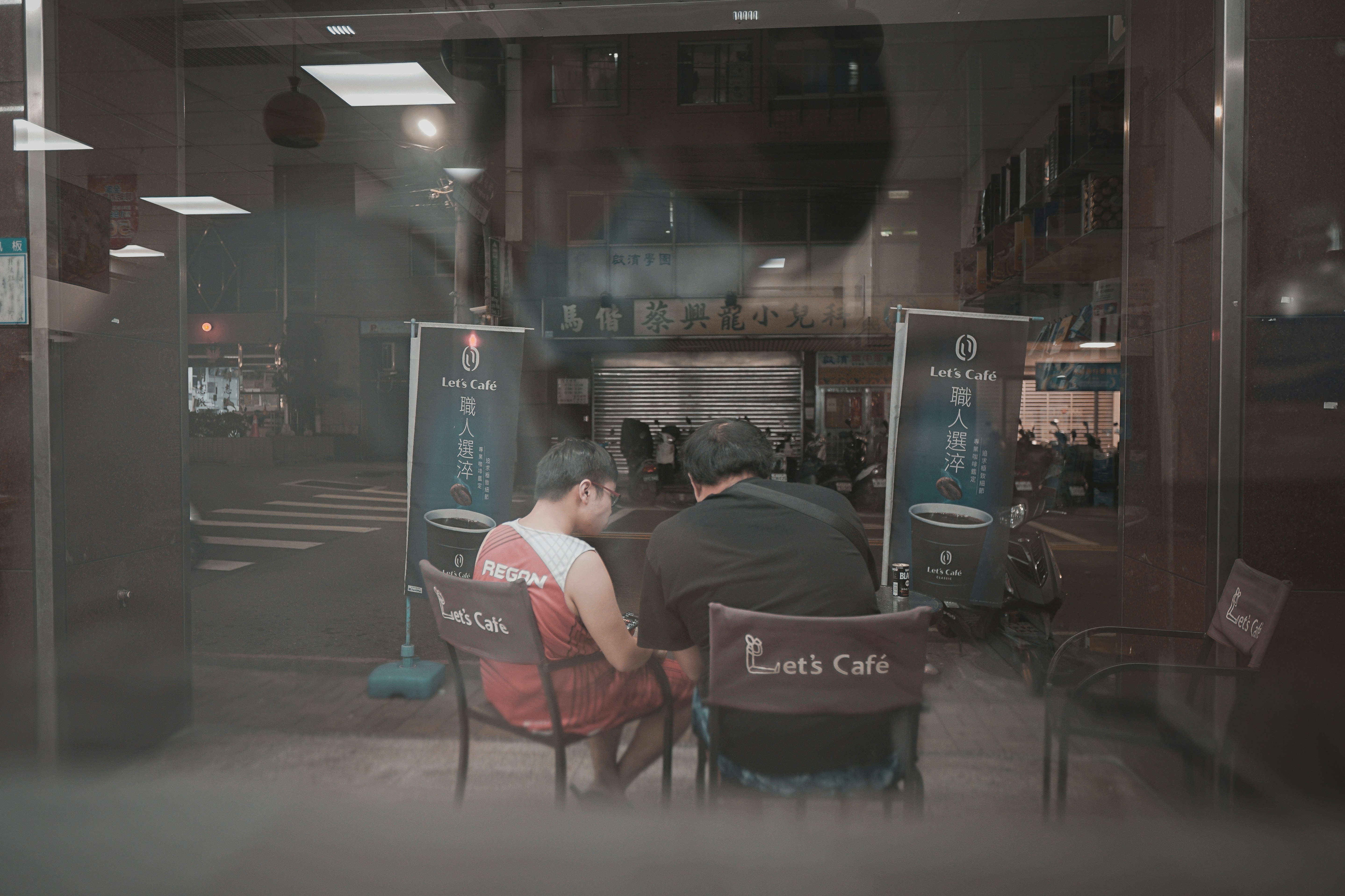 man in black jacket sitting on red chair